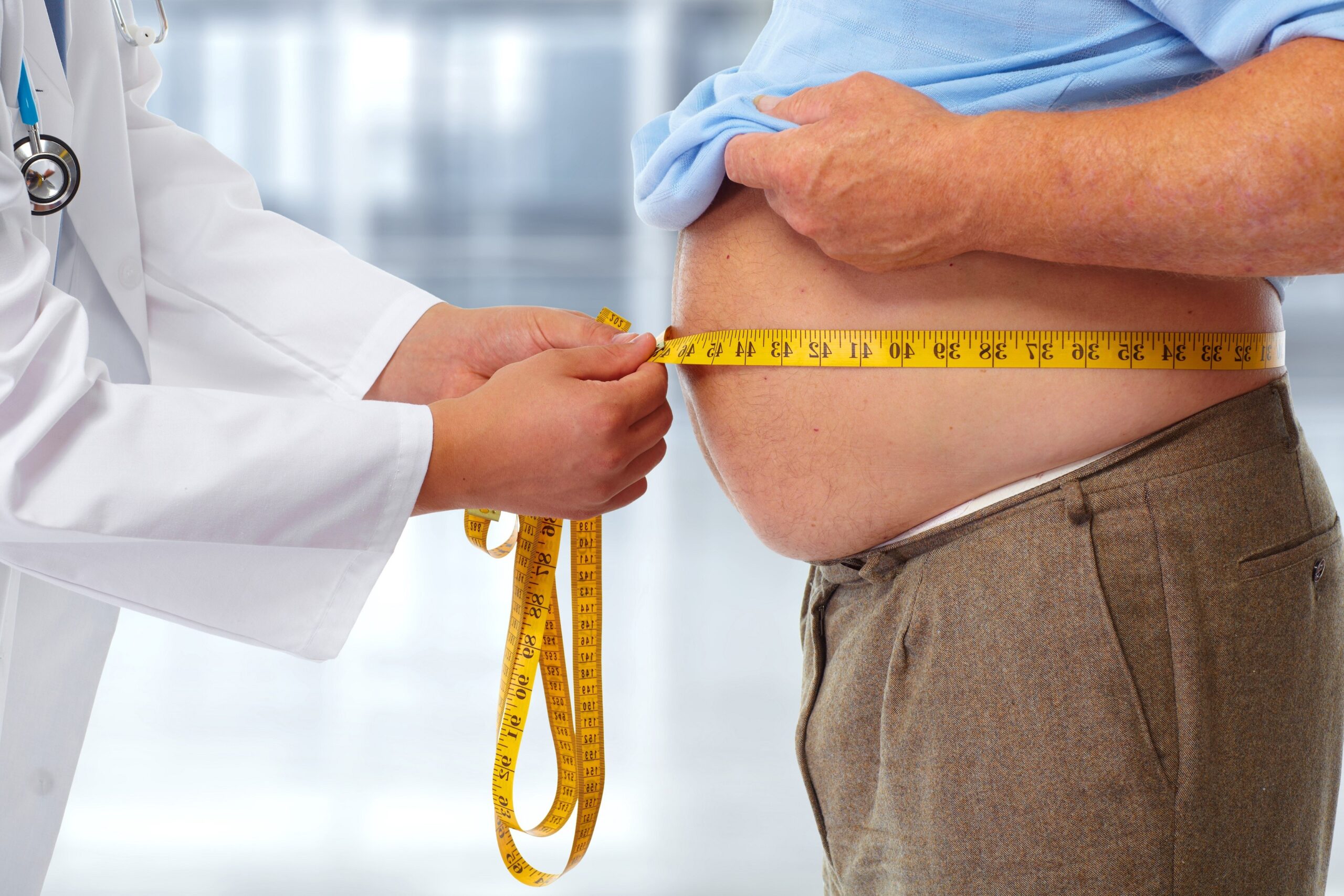 Image of a doctor measuring the size of a patient's abdomen