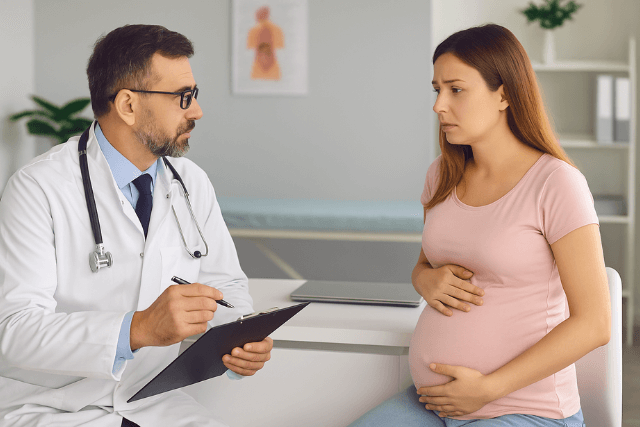 Pregnant woman consulting with a doctor about Hemorrhoids During Pregnancy in a medical office.