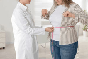 Medical Weight Loss Clinic in the Southeast: Nutritionist Measuring Woman's Waist Wit