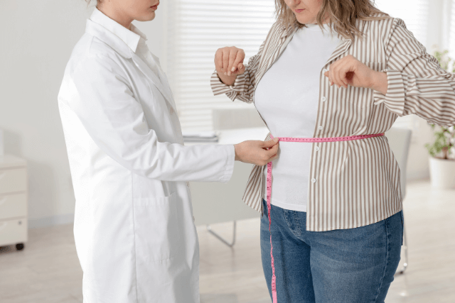Medical Weight Loss Clinic in the Southeast: Nutritionist Measuring Woman's Waist Wit